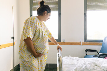 Woman with heavy pregnancy in delivery gown at hospital