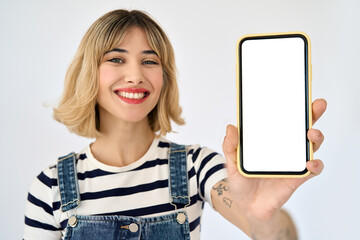 Happy young gen z blonde woman shopper girl student holding smartphone using mobile cell phone showing big mockup screen presenting shopping sale application on cellphone isolated on background. - obrazy, fototapety, plakaty