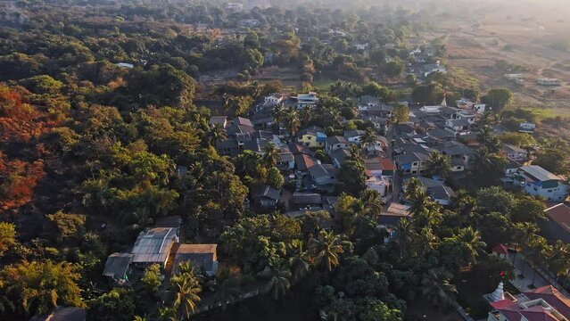Aerial shot of a beautiful Village Mandwa near Alibuag captures the top traditional homes and the surrounding palm or coconut trees. 