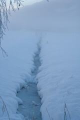 frozen creek at a cold winter morning