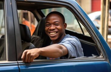 A smiling man sitting in the driver's seat of a blue truck