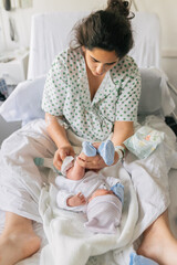 Young mother changing diaper of infant