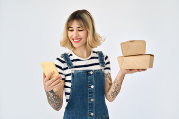 Happy gen z blonde young woman, girl customer holding smartphone and food delivery boxes using...