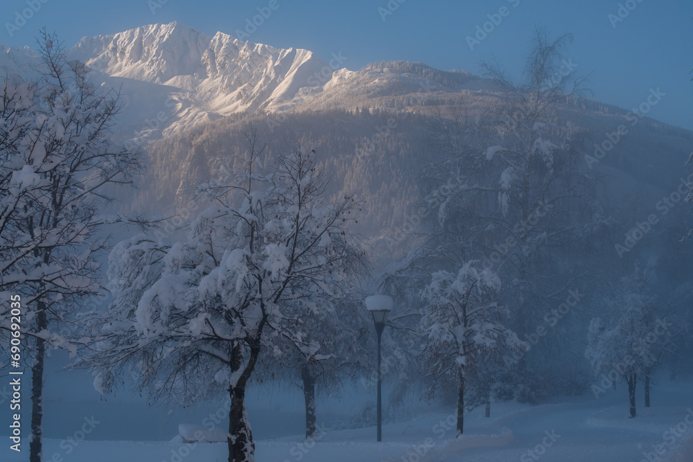 Wall mural walking in the winter landscape in the austrian mountains at a foggy and cold morning