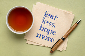 fear less, hope more - words of wisdom on a napkin with tea, stress and personal development concept