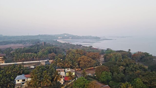 Aerial view of a beautiful village on an island surrounded by coconut trees in Mandwa beach near Alibuag, Maharashtra, India. 