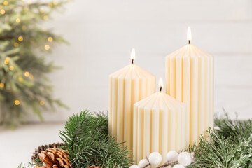 Christmas decoration with candle on texture background. New Year and Christmas candles. Cozy home decor. Burning candle and Christmas decoration. Christmas lights. Copy space.Holiday concept. 