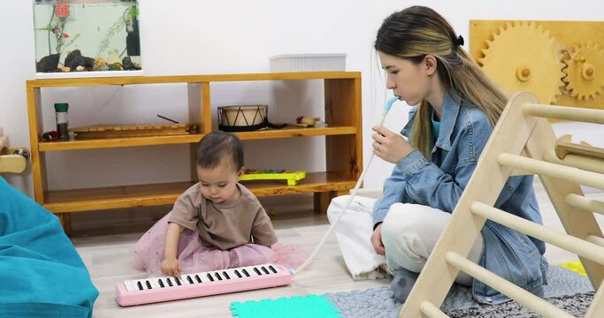 Toddler and mother playing toy piano