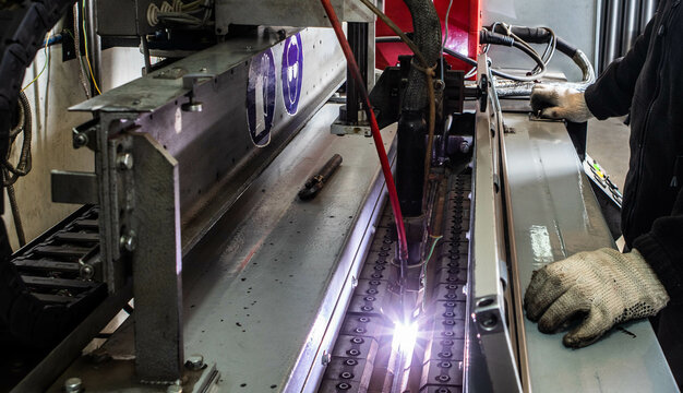 Working overlap arc welding machine. Welded seam. Welding sparks.