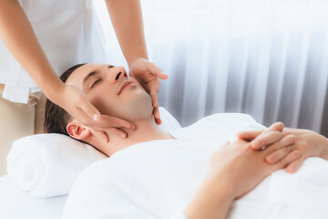 Obraz na płótnie Canvas Caucasian man enjoying relaxing anti-stress head massage and pampering facial beauty skin recreation leisure in dayspa modern light ambient at luxury resort or hotel spa salon. Quiescent