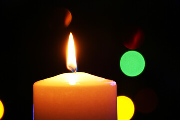 Christmas candle on the background of a beautiful Christmas tree.