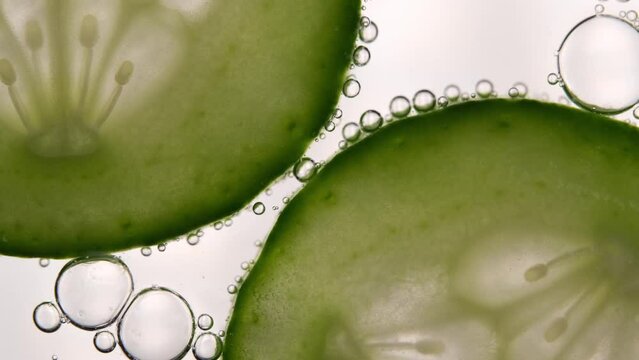 Close-up of cucumber on top of fizzy soda