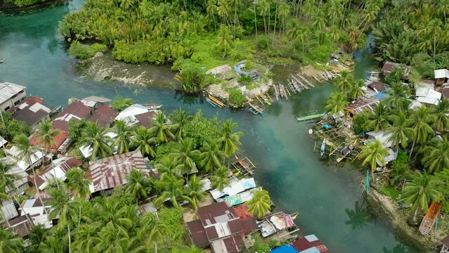 Panorama view of Bogac Cold Spring surrounded by tropical forest and fishermen houses. Surigao del Sur. Philippines.