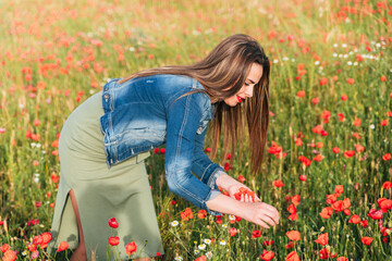 Young female picking poppy petals