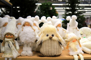 Santa Clause and Christmas dolls near Christmas tree, on store window. Beautiful favorite toys for New Year. Christmas winter shop shopping