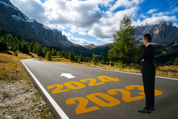 2024 New Year journey and future vision concept . Businessman traveling on highway road leading...