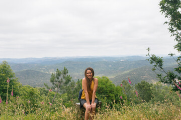 Cheerful female tourist against mountains