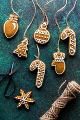 A variety of decorated gingerbread cookie ornaments with twine attached.