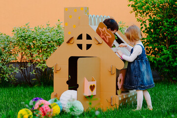 Children painting on the cardboard playhouse.