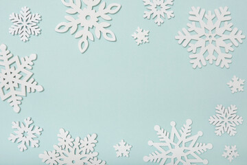Festive frame made of wooden snowflakes on a blue background. Winter, Christmas, New Year concept.