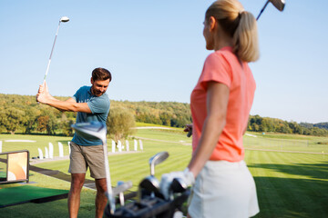Naklejka premium Dynamic Duo Practicing Golf Techniques