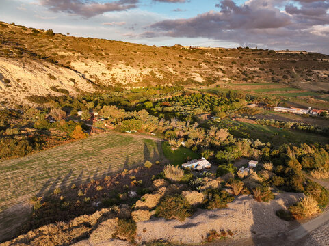 Sunset over Cyprus Kurion Beach, where golden hues dance on the serene Mediterranean waters, casting a tranquil glow. The sun kisses the horizon, painting the sky with warm shades of orange and purple