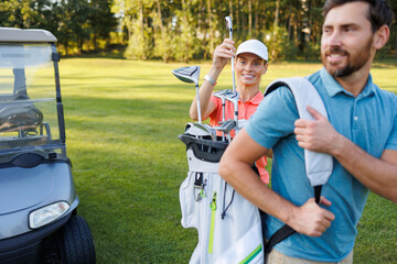 Couple Enjoying Golf: Woman Retrieving Club from Man's Bag