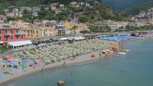 Five Lands, Italy - summer2023: tourists stroll on the beach of Moneglia.