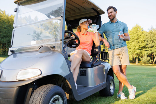 Golfing Relaxation: Couple Drinking Water on Cart
