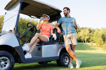 Golf Course Break: Couple Sipping Water on Cart