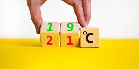 19 or 21 degrees Celsius symbol. Concept word 19 or 21 degrees Celsius on cubes. Beautiful yellow table white background. Lowering temperature to reduce energy consumption concept. Copy space.