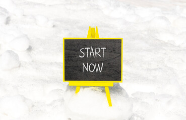Start now symbol. Concept words Start now on beautiful black chalk blackboard. Beautiful white snow...