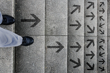 Eine Frau steht auf einer Treppe und muss entscheiden in welche Richtung sie gehen will