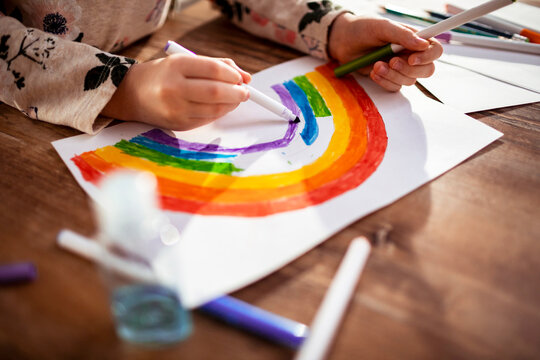 Close up child hands drawing rainbow
