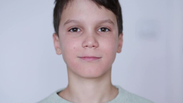 A boy puts on retainers, on a white background. Concept of correcting crooked teeth and occlusion in a child, installing a jaw expander.