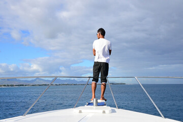 Mauritius, sailor standing on the bow of a boat near Port Louis