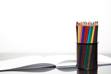 Colored pencils in a stand on a mirror surface. - Powered by Adobe