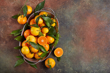 A dish with oranges and tangerines with leaves. Freshly picked up harvest of citrus fruits. Blank...