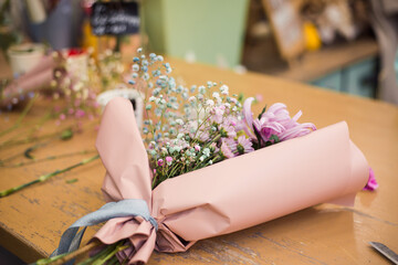 fresh flowers on table wrapped in paper, flower shop business
