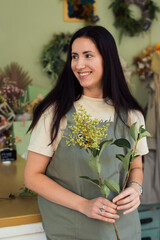 happy woman florist posing at flower shop with flower 