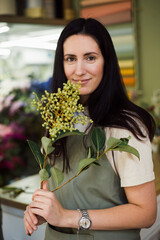happy woman florist posing at flower shop with flower 