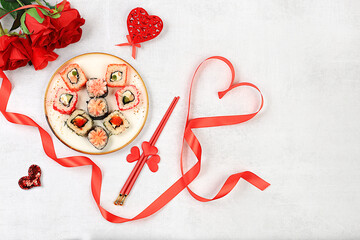 Heart made of fresh sushi rolls with roses, Valentine's Day food, traditional Japanese cuisine, banner for advertising or bar invitation, menu, space for text, top view,