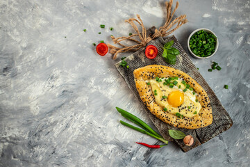 Khachapuri cheese and egg filled bread on a wooden board, top view. copy space