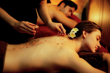 Couple customer having exfoliation treatment in luxury spa salon with warmth candle light ambient....