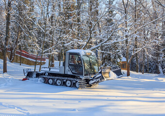 Fototapeta na wymiar Tractor cleaning the ski slope