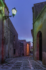 A characteristic alley of the Erice medieval town at nightfall, Sicily - 690751233