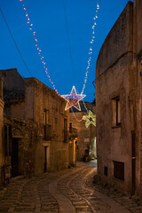 A characteristic alley with Christmas lights in the medieval town of Erice, Sicily  - 690751862