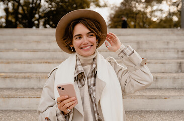 pretty smiling woman walking in park in autumn clothes
