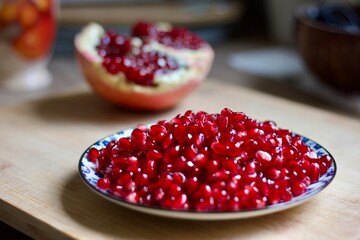 pomegranate seeds in a bowl and a half of a fruit