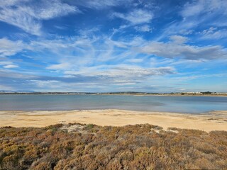 Horizon and mountains in the distance. View of the lagoon in Spain. Blue sky and clouds.